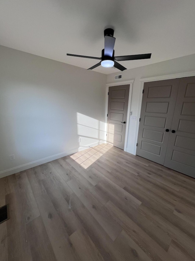 unfurnished bedroom with light hardwood / wood-style flooring, a closet, and ceiling fan