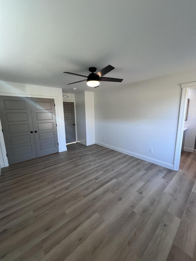 unfurnished bedroom featuring wood-type flooring and ceiling fan