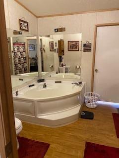 bathroom with ornamental molding, a bathtub, and hardwood / wood-style floors