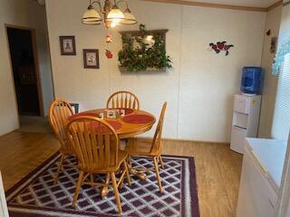 dining room featuring wood-type flooring, an inviting chandelier, and crown molding