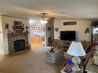 living room featuring a fireplace and ceiling fan