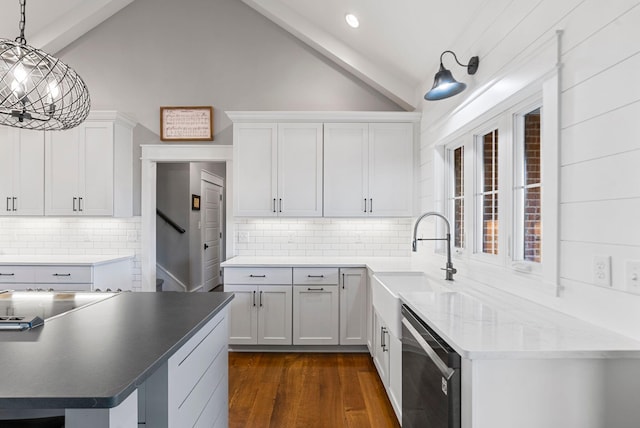 kitchen with sink, white cabinetry, hanging light fixtures, dark hardwood / wood-style floors, and stainless steel dishwasher