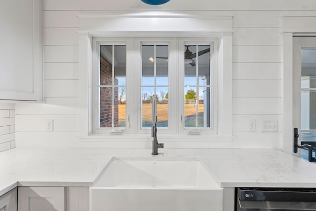 room details featuring dishwasher and light stone counters