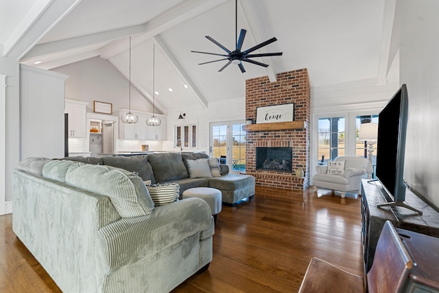 living room with beamed ceiling, plenty of natural light, dark hardwood / wood-style floors, and a fireplace