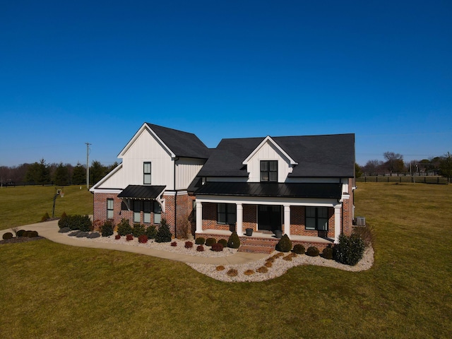 modern farmhouse with a front yard and covered porch