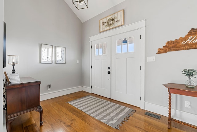 entryway featuring plenty of natural light, high vaulted ceiling, and light wood-type flooring