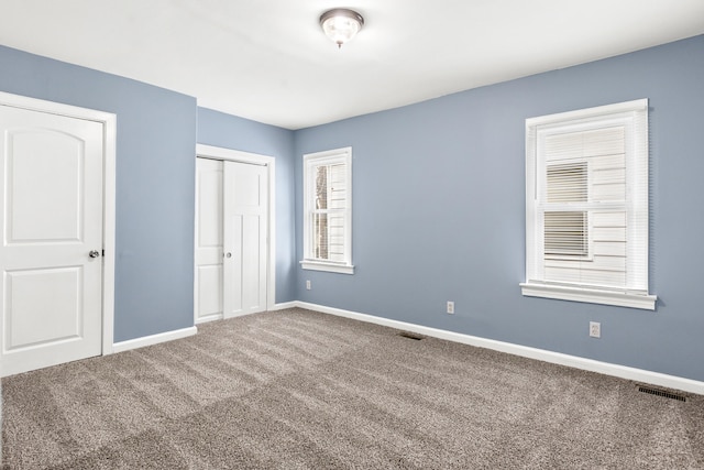 unfurnished bedroom featuring carpet floors and a closet