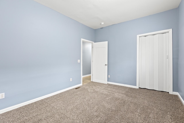 unfurnished bedroom featuring carpet flooring and a closet