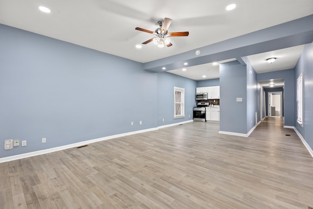 unfurnished living room featuring ceiling fan and light hardwood / wood-style flooring