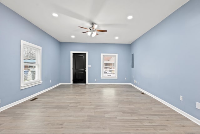 spare room with ceiling fan, plenty of natural light, and light hardwood / wood-style floors