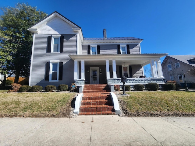 view of front of house featuring covered porch and a front yard