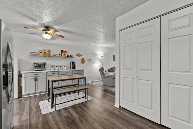 dining space featuring ceiling fan, dark hardwood / wood-style floors, and a textured ceiling