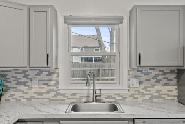 kitchen featuring sink, gray cabinetry, and decorative backsplash