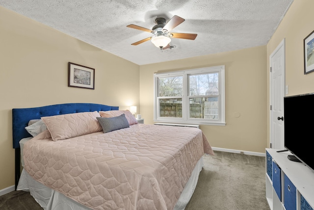 bedroom with ceiling fan, carpet floors, and a textured ceiling