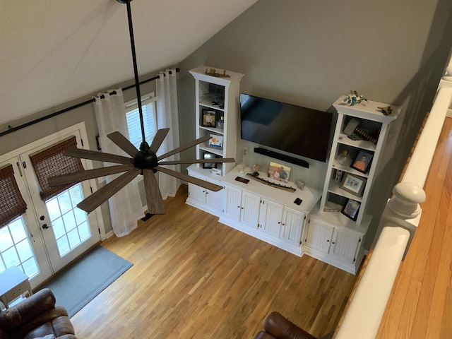 living area with light wood-style floors and vaulted ceiling