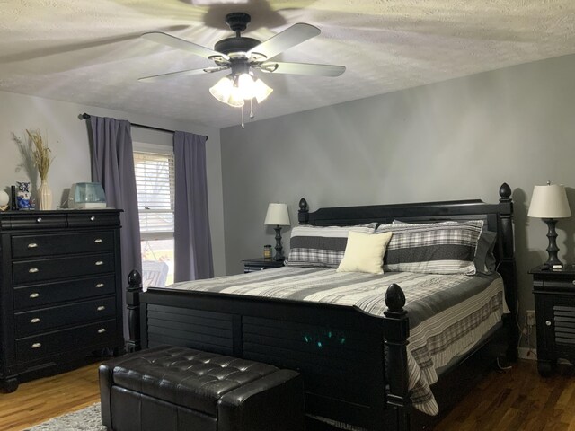 bedroom with ceiling fan, ensuite bathroom, dark hardwood / wood-style flooring, and a textured ceiling