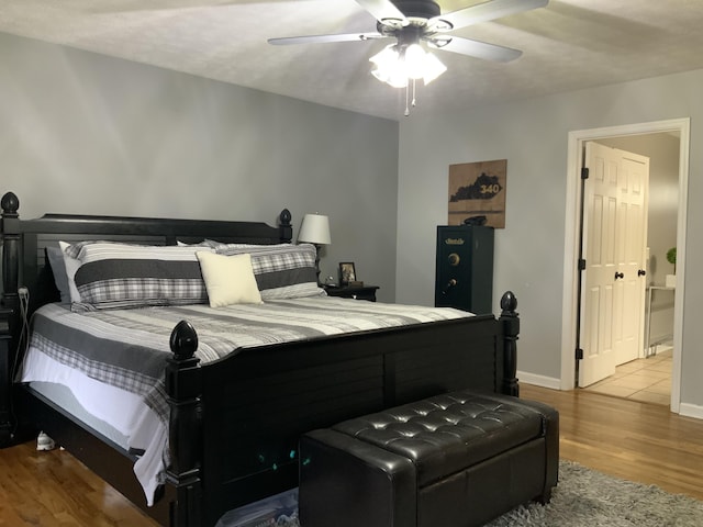 bedroom with ceiling fan, baseboards, and wood finished floors