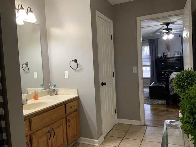 bathroom with baseboards, ceiling fan, vanity, and tile patterned flooring