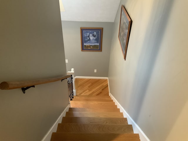 stairway featuring baseboards and wood finished floors