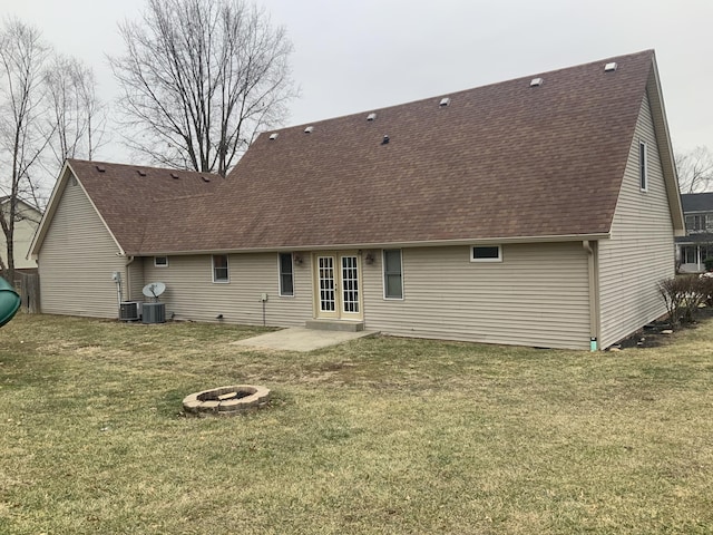 back of property featuring an outdoor fire pit, french doors, a yard, a shingled roof, and a patio area