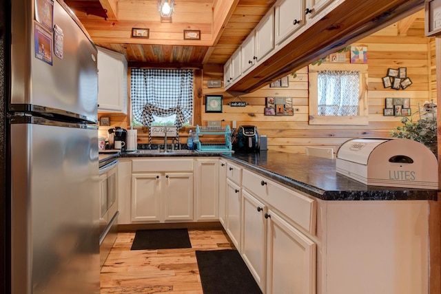 kitchen with white cabinets, light wood-type flooring, stainless steel fridge, and wood ceiling