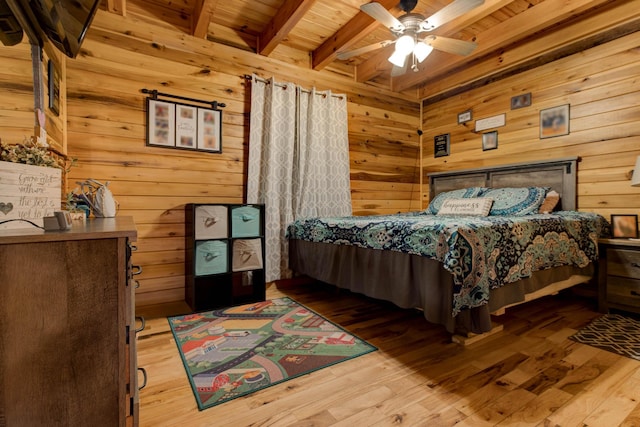 bedroom with wood walls, wood ceiling, wood-type flooring, beamed ceiling, and ceiling fan