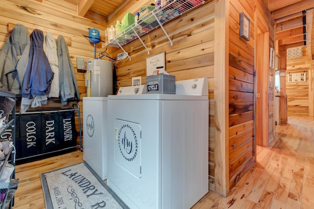 washroom featuring separate washer and dryer, light hardwood / wood-style flooring, and wood walls