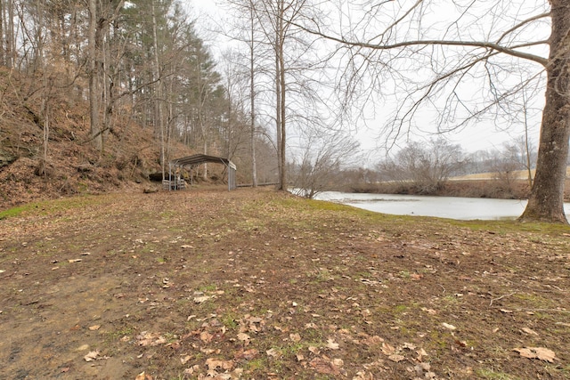 view of yard with a water view and a carport