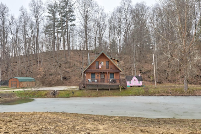 view of front of property featuring a deck and a storage unit