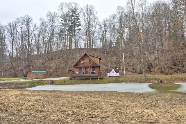 exterior space featuring a deck with water view and a storage unit