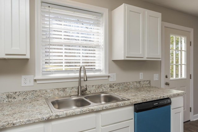 kitchen with dishwashing machine, sink, and white cabinetry