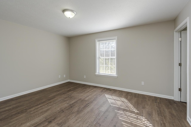 empty room featuring dark wood-type flooring