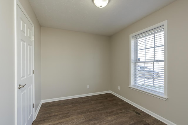 empty room featuring a textured ceiling and dark hardwood / wood-style flooring