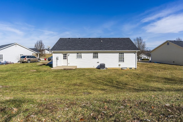 rear view of house with a yard and central AC