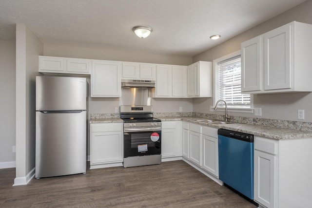 kitchen featuring appliances with stainless steel finishes, sink, dark wood-type flooring, and white cabinets