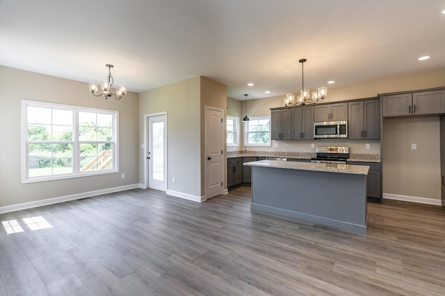 kitchen with stainless steel appliances, an inviting chandelier, and decorative light fixtures