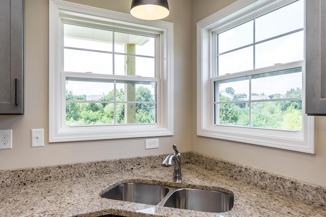 interior details featuring light stone counters and sink