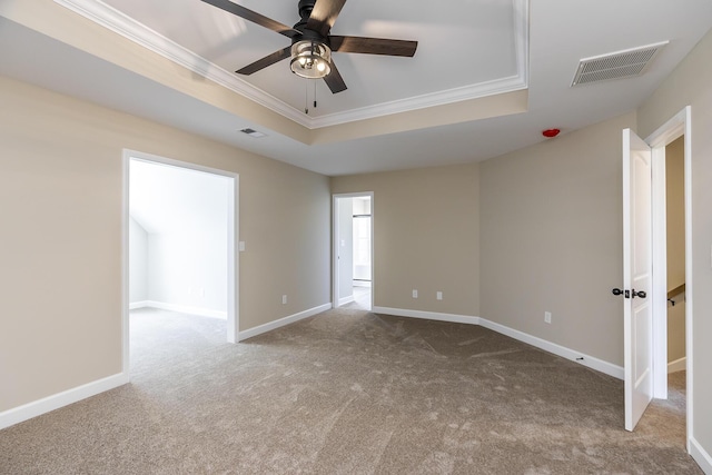 empty room with light carpet, ornamental molding, a raised ceiling, and ceiling fan