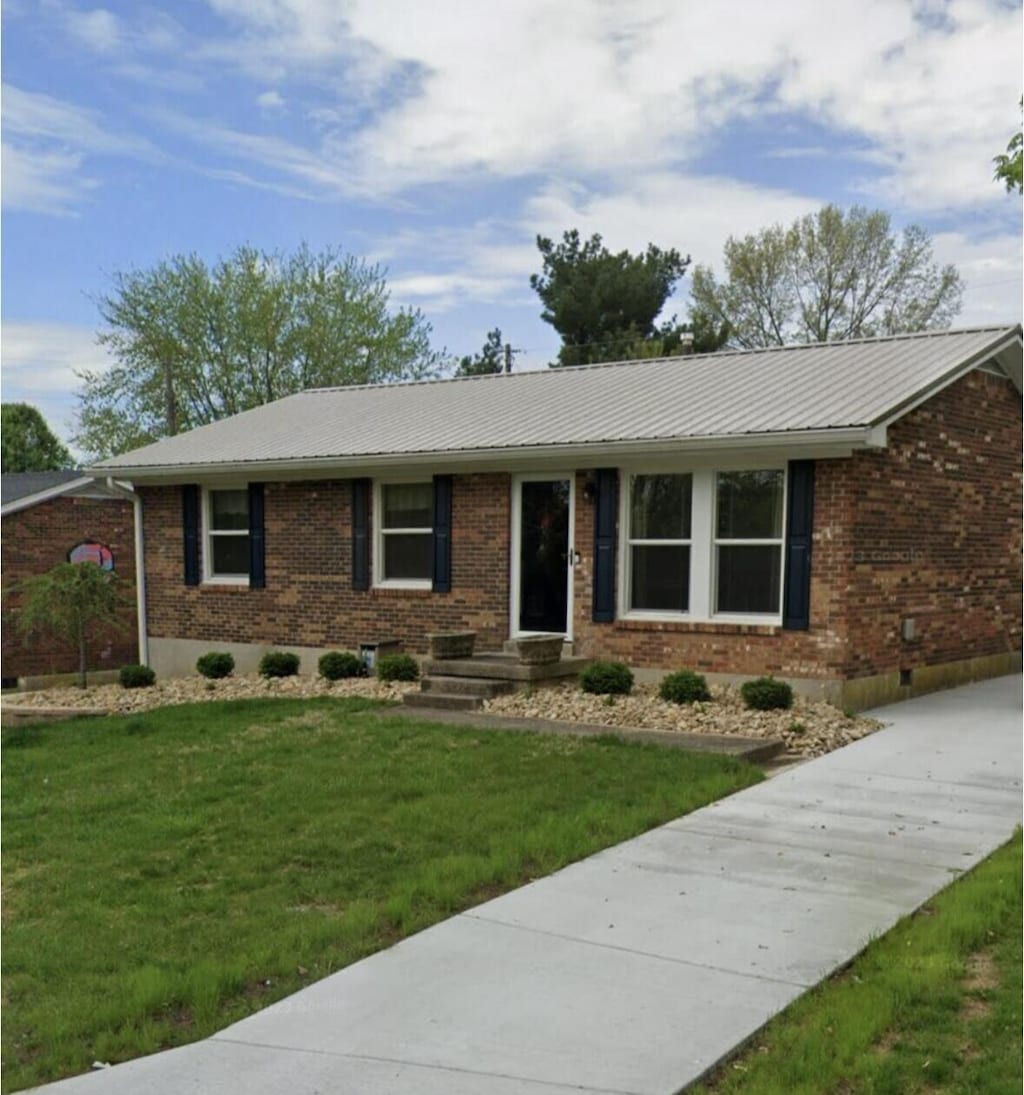 ranch-style home featuring a front lawn