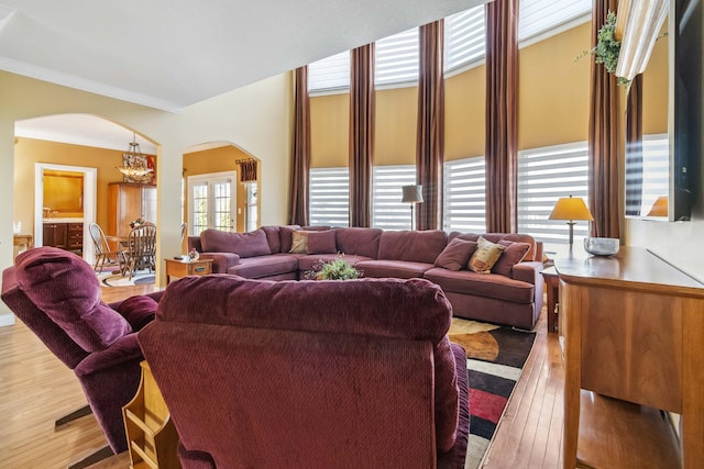 living room with ornamental molding, light hardwood / wood-style floors, and a chandelier