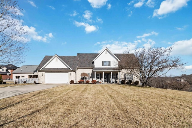 view of front of home featuring a garage, a front yard, and a porch