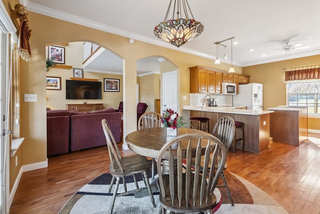 dining area with hardwood / wood-style flooring, ornamental molding, and ceiling fan