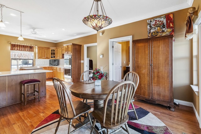 dining area featuring ceiling fan, ornamental molding, and hardwood / wood-style floors