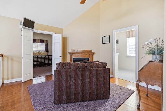 living room featuring hardwood / wood-style flooring, ceiling fan, and high vaulted ceiling