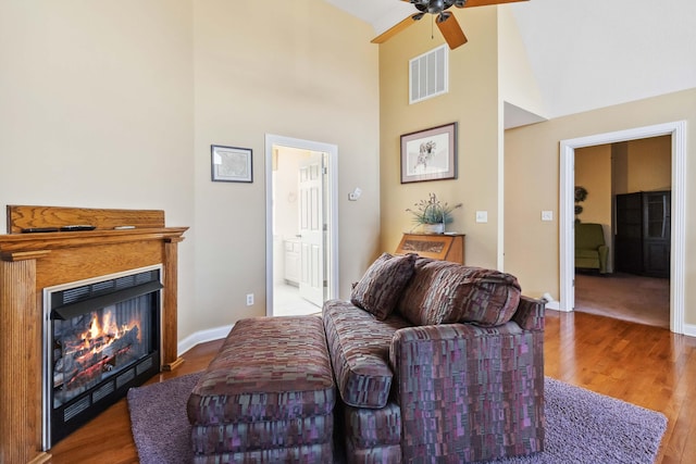 living room with hardwood / wood-style floors, high vaulted ceiling, and ceiling fan