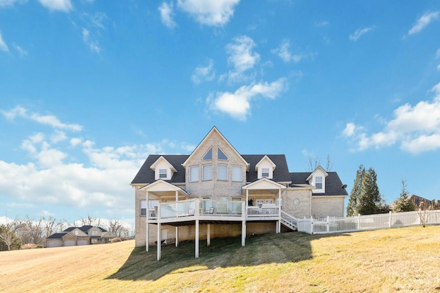 rear view of house with a wooden deck and a yard