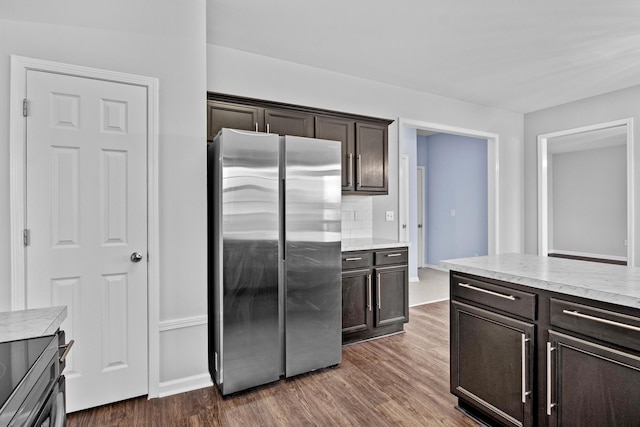 kitchen featuring dark wood-type flooring, light countertops, dark brown cabinets, and freestanding refrigerator