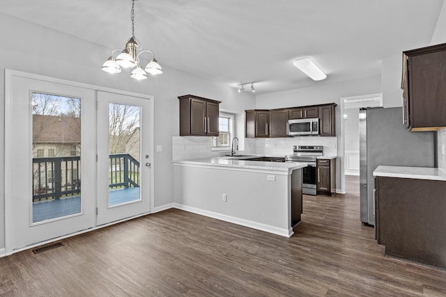 kitchen featuring hanging light fixtures, visible vents, appliances with stainless steel finishes, and light countertops