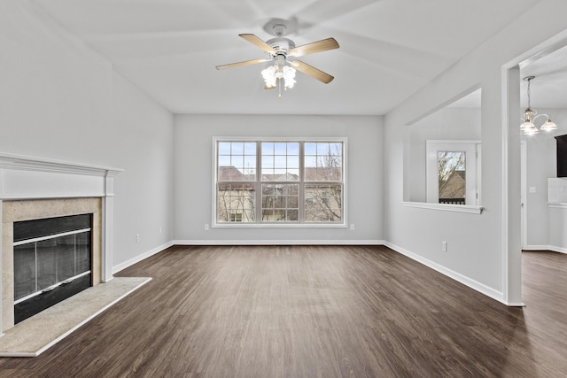 unfurnished living room with dark wood-style floors, a premium fireplace, and baseboards