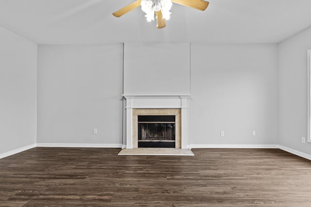 unfurnished living room featuring ceiling fan, baseboards, a fireplace with raised hearth, and dark wood-style flooring